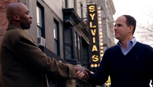 Marcus Lemonis congratulates Tonnie, owner of a cupcake shop, in marketing deal. (Courtesy of CNBC)